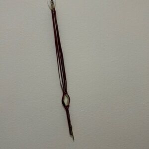 Long maroon pleather necklace with gold accents